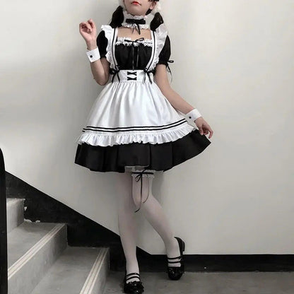 Disfraz sirvienta japonesa con lazos negros y medias blancas posando en escalera